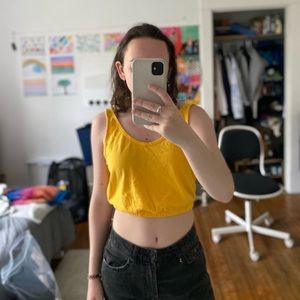 Yellow cropped tank top with elastic hem.